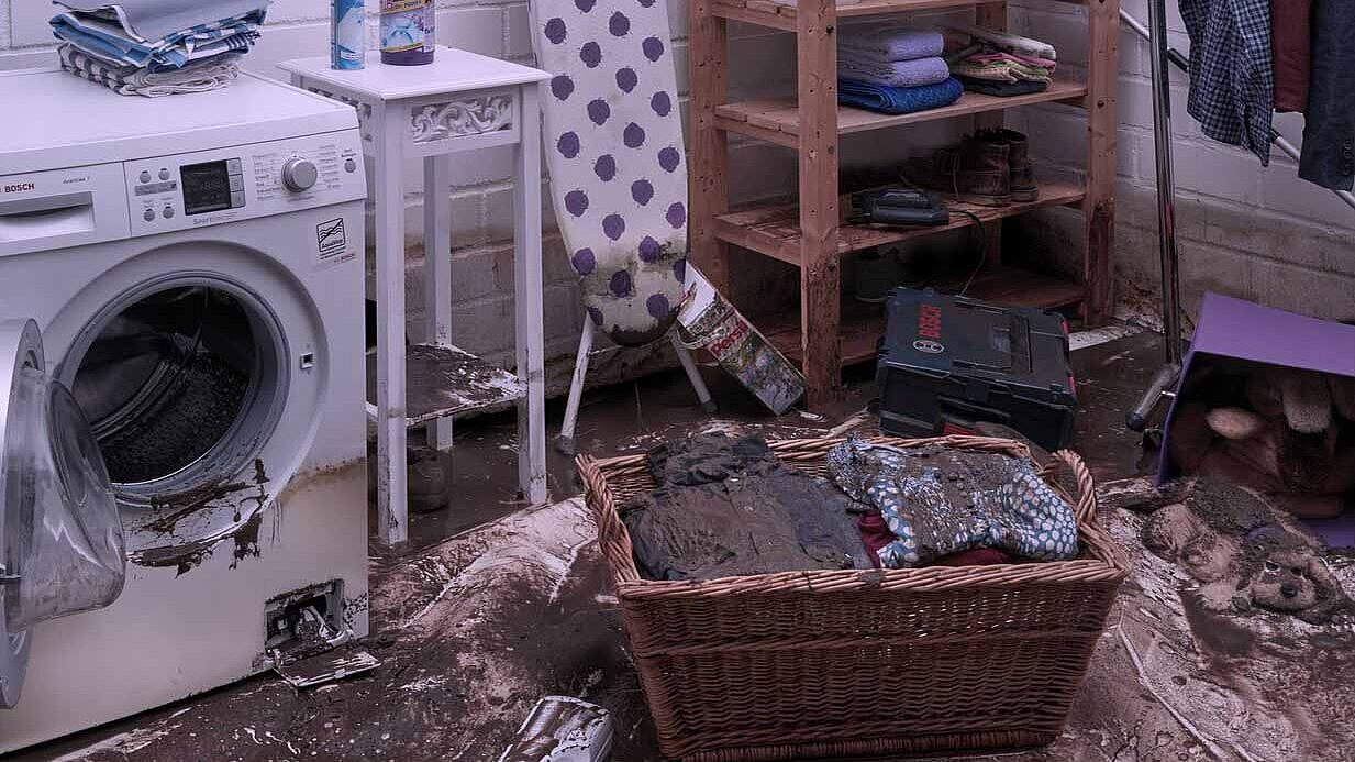 Damage to the laundry room Laundry room with a dirty laundry basket and a washing machine.